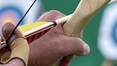 Image of a notched arrow with archery targets in the background.